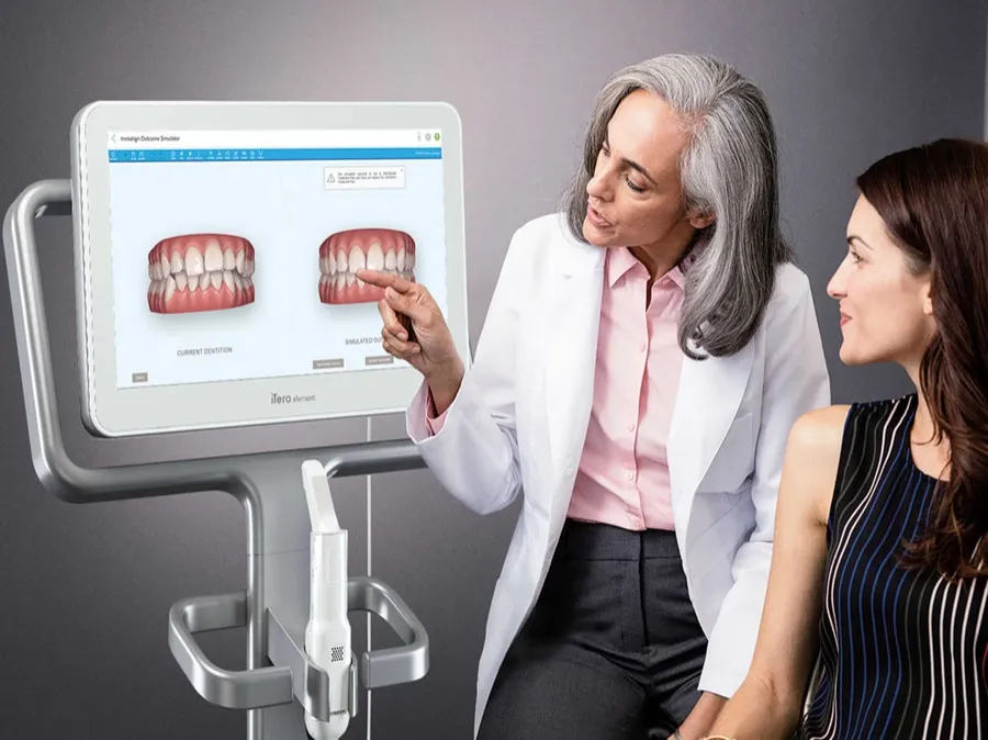 A dentist showing a patient her intraoral scan on a monitor